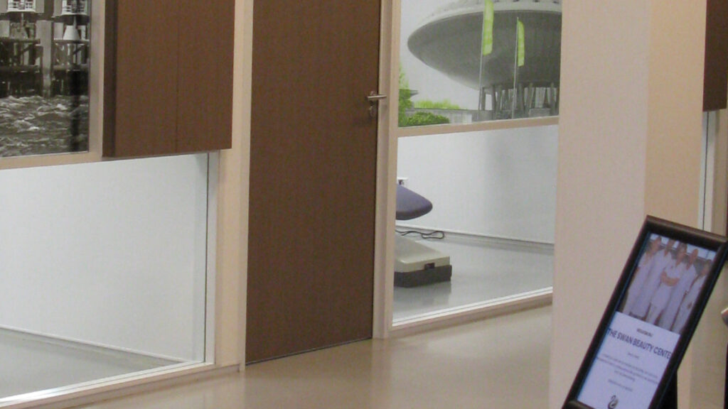 Ingang van behandelkamer met zicht op tandartsstoel en foto aan de muur bij Tandarts Alkmaar Oudorp