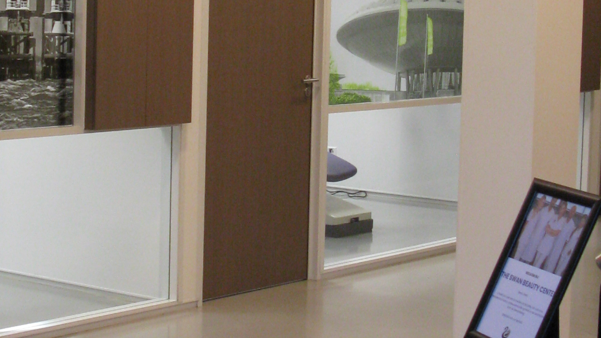 Ingang van behandelkamer met zicht op tandartsstoel en foto aan de muur bij Tandarts Alkmaar Oudorp