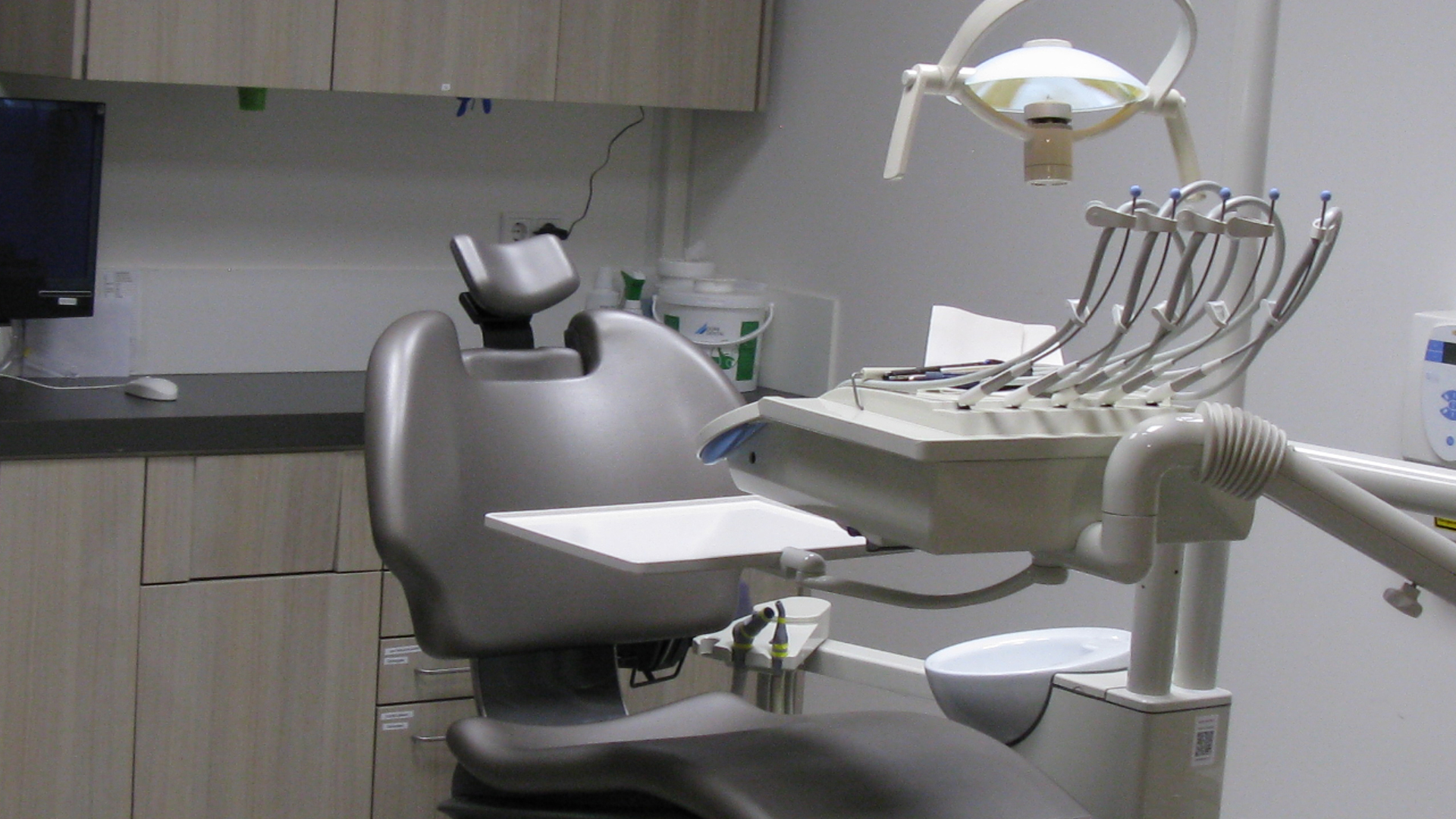 Grijze tandartsstoel met apparatuur in moderne behandelkamer van Tandarts Alkmaar Oudorp