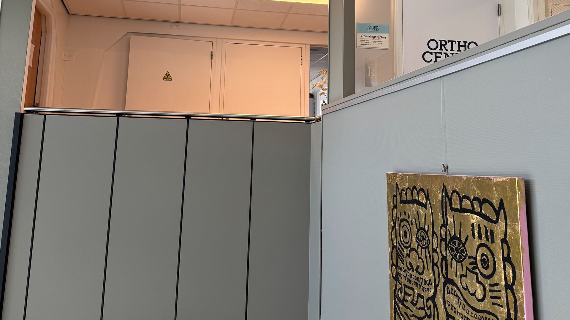 Overloop met schilderij en bordje Ortho Center bij Tandarts Alkmaar Oudorp