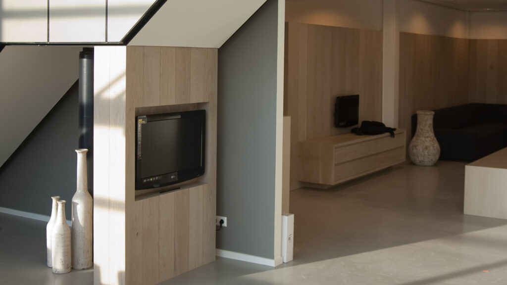 Doorkijk vanaf trap naar behandelruimtes met houten wanden bij Tandarts Alkmaar Oudorp