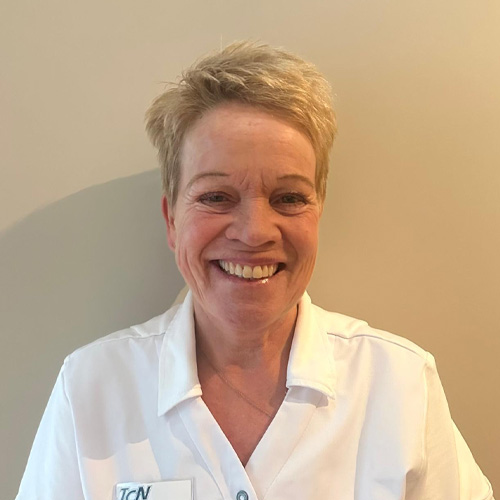 Esther, werkzaam bij Tandheelkundig Centrum Nederland, lachend in witte werkjas