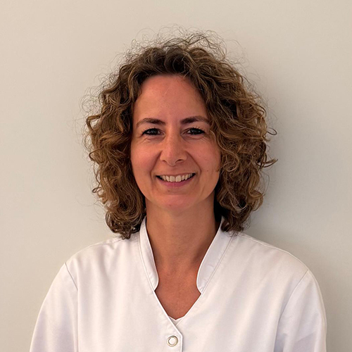 Sandra, werkzaam bij Tandheelkundig Centrum Nederland, lachend in witte werkjas