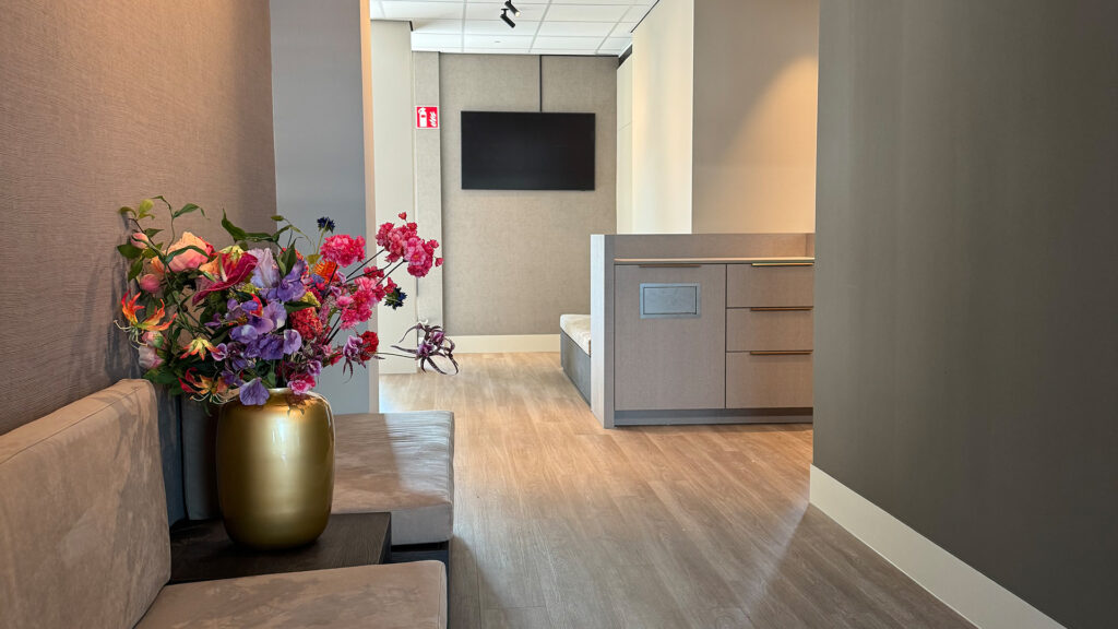 Zijkant van de wachtkamer van Tandarts Beverwijk met bloemen en zitbank