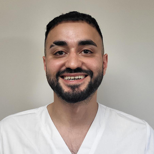 Ilyas, werkzaam bij Tandheelkundig Centrum Nederland, lachend in witte werkjas