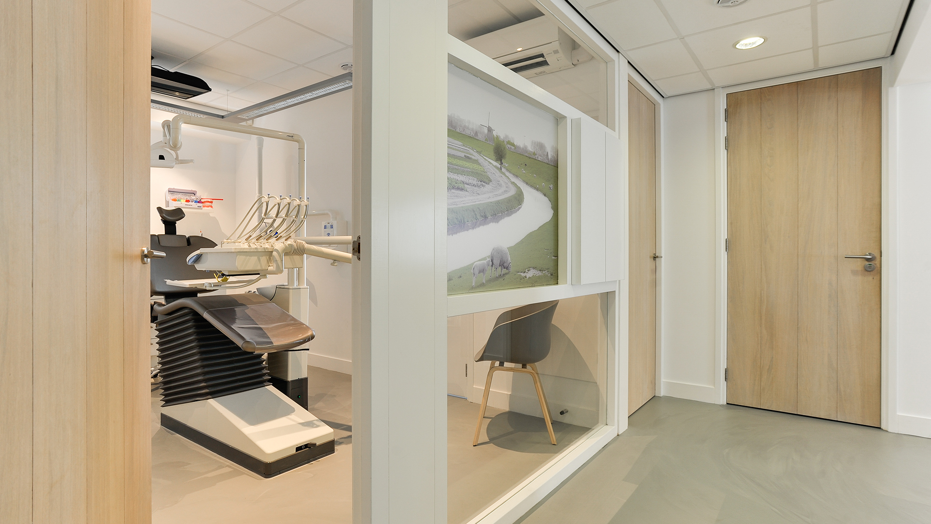 Behandelkamer met moderne tandartsstoel en wanddecoratie bij Tandarts Heerhugowaard