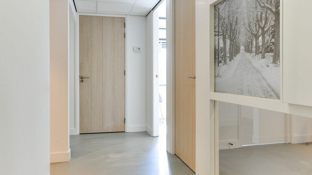 Hal met houten deuren en winterse wanddecoratie bij Tandarts Heerhugowaard