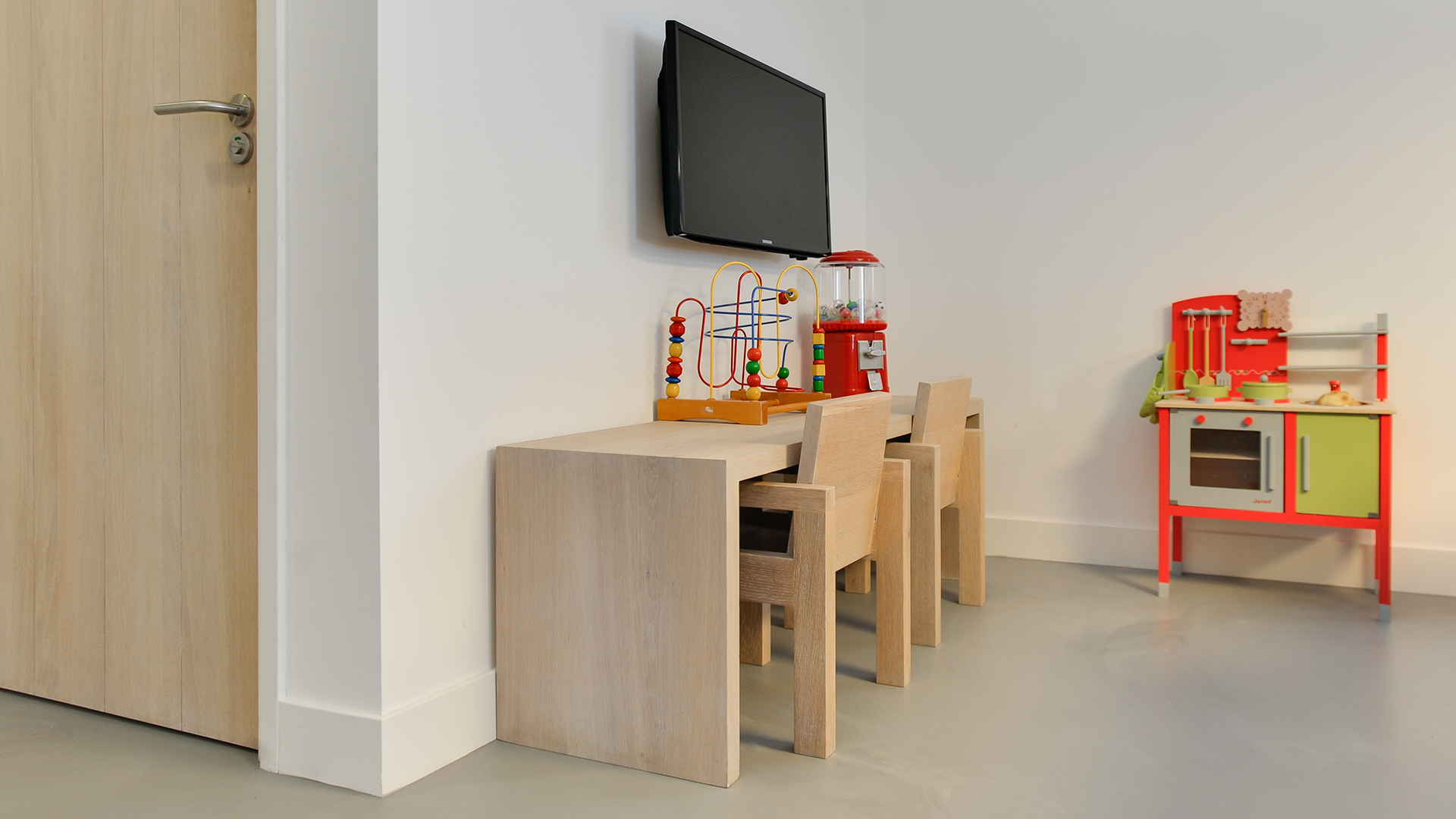 Kinderhoek met houten tafeltje, stoelen en speelgoed bij Tandarts Heerhugowaard