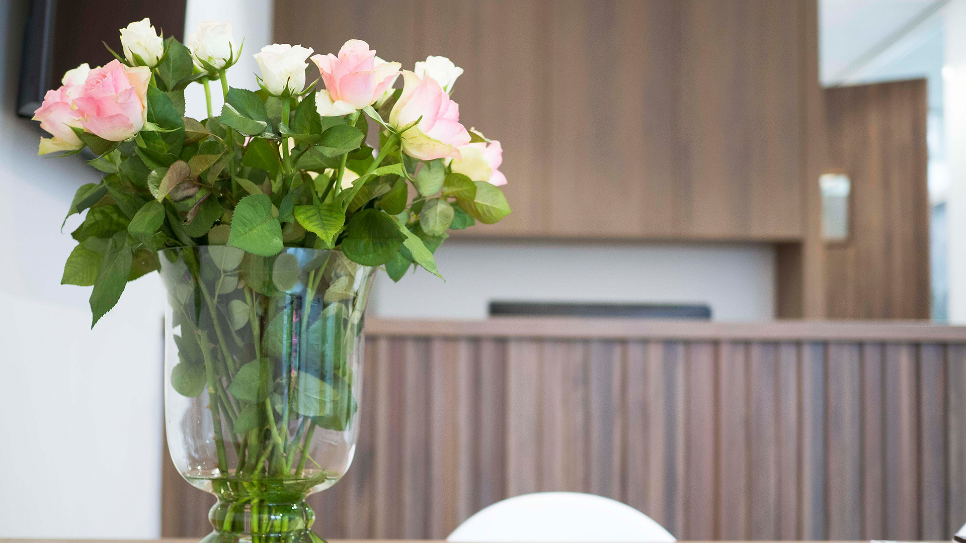 Rozen in glazen vaas op tafel in wachtruimte van Tandarts Westzaan