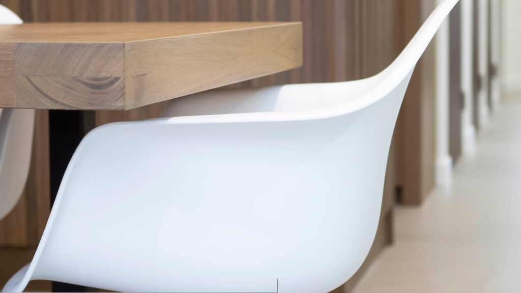 Designstoel aan houten tafel in wachtruimte van Tandarts Westzaan