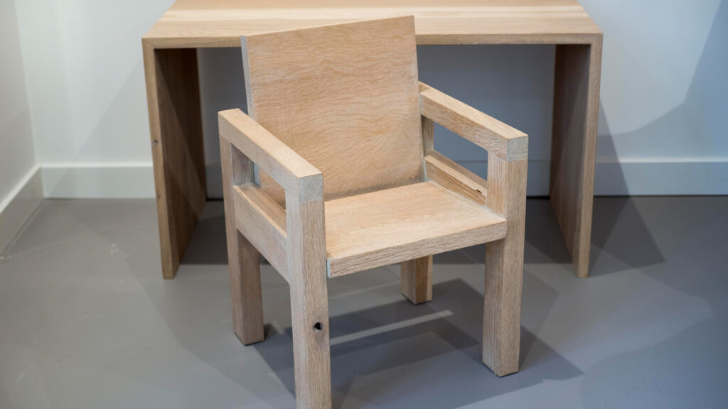 Houten kinderstoel bij tafel in wachtruimte van Tandarts Westzaan