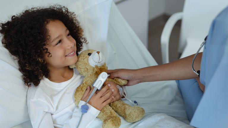 Kind met knuffel tijdens behandeling, lange termijn effecten kinderkanker op gebit