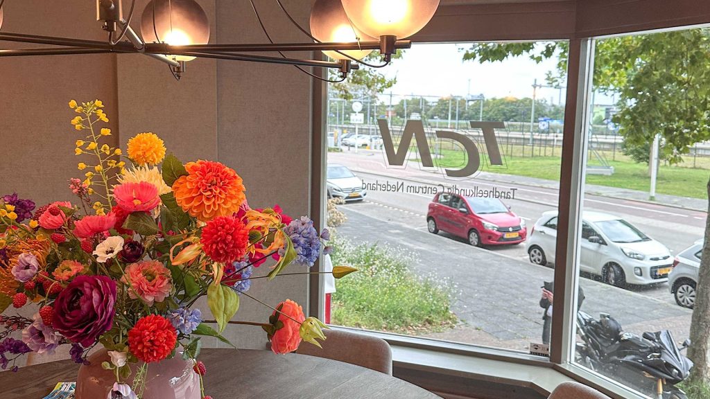 Wachtruimte met grote ramen met TCN logo sticker op raam in TCN Beverwijk