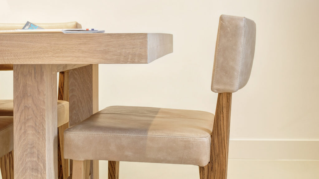 Leren stoel en houten tafel in wachtruimte bij Tandarts Castricum