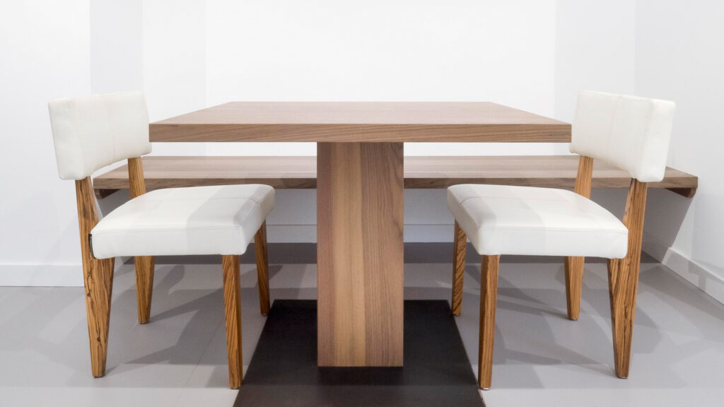 Moderne houten tafel met witte stoelen in wachtruimte van Tandarts Westzaan